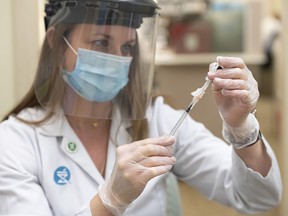 Pharmacist Alison Davison prepares a dose of Pfizer-BioNTech COVID-19 vaccine at Shoppers Drug Mart pharmacy on 17 Ave. S.W. in Calgary on Friday, March 5, 2021.