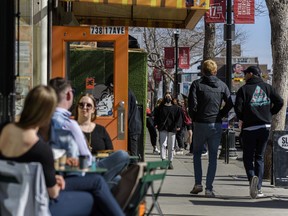 People spend the sunny afternoon on 17 Avenue as more businesses are open for in-person services on Friday, March 19, 2021. The province is looking at opening up more businesses and services in the coming week, but variants of concern are also on the rise.