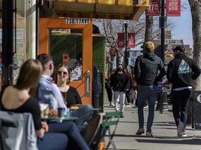 People spend the sunny afternoon on 17 Ave. S.W. as more businesses are open for in-person services on Friday, March 19, 2021.