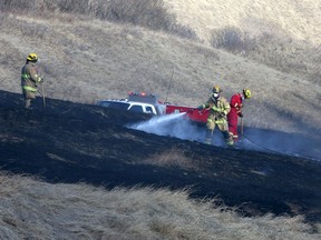 Firefighters battle a grassfire off Deerfoot Trail southbound near the Memorial Dr. exit close to the Max Bell Centre. Saturday, March 20, 2021.