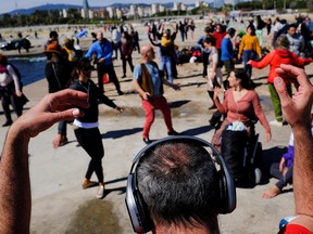 Barcelona residents use their headphones while listening to music as they dance during a socially-distant silent disco event on the first Spring weekend at Mar Bella beach in Barcelona, Spain March 21, 2021.