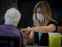 Stacey Israelson, RN, administers a COVID-19 vaccine to a resident at Aspen Ridge Lodge Seniors' Housing in Didsbury, Alberta.