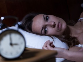 Woman lying in bed suffering from insomnia. Stock image. Getty Images/iStock Photo Stock; woman; clock; insomnia; sleep