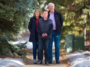 Anne McWhir and David Oakleaf stand with their son Stephen near their northwest Calgary home on Wednesday, March 3, 2021. Stephen, who has Down syndrome, spoke about his experience dealing with the COVID-19 pandemic over the past year.