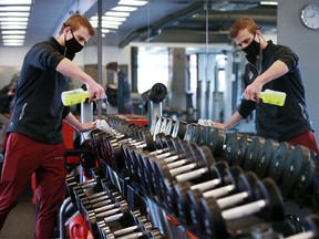 Urban Athlete Fitness Studio owner Kohl Kehler sanitizes equipment in preparation for the lifting of some pandemic restrictions on fitness facilities on Monday, March 1, 2021.