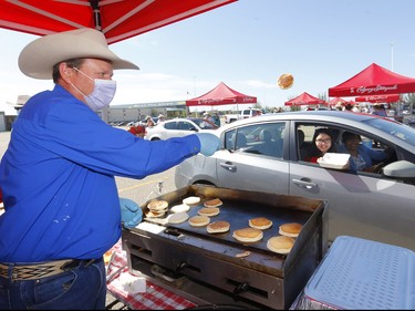 Calgary Stampede President & Chairman of the Board, Dana Peers has some fun with Katrina Pauls during the community pancake drive-thru presented by GMC at CrossIron Mills  on Saturday, July 4, 2020. The Calgary Stampede was cancelled but organizers still found ways to keep the Stampede spirit alive with drive thru midway food pancake breadfasts and a special fireworks display.
Darren Makowichuk/Postmedia