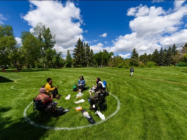 A group of friends spend the sunny day hanging out in a physical distancing circle painted in Riley Park on Tuesday, June 9, 2020. Azin Ghaffari/Postmedia