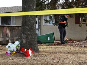 A memorial marks the scene as police forensics officers search the area near a suspicious death in the 5200 block of Memorial Drive S.E. on Sunday, March 28, 2021. Shots were fired on Saturday evening March 27 leading to the death.
