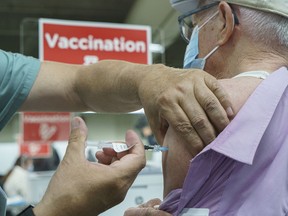 An elderly man receives a COVID-19 vaccination at Olympic Stadium in Montreal, on Monday, March 1, 2021.