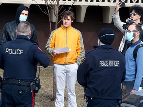 Churchgoers are seen interacting with police and bylaw officers outside the Fairview Baptist Church in the SE. Sunday, March 7, 2021.