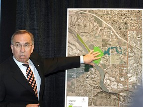 Dick Haskayne points to a large map of the city showing where in the city the park will be located during a press conference at Old City Hall in Calgary on November 15, 2006.