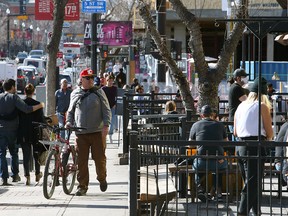People are seen enjoying a spring afternoon along 17th Ave. SW. Friday, March 12, 2021.