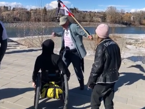 A video posted to social media appears to show an altercation as described by Calgary Police of a man holding a flagpole punching a man in a wheelchair at Prince's Island Park after an anti-mask rally on March 20.
