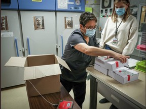 Alberta Health workers handle a shipment of AstraZeneca vaccine on March 9, 2021, in this photo from Health Minister Tyler Shandro's Twitter account.