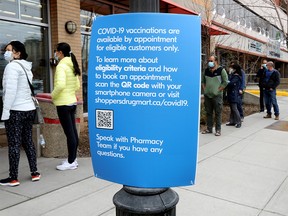 Patrons wait outside of the Shoppers Drug Mart in Kensington as they are taking appointments for COVID vaccines in Calgary on Wednesday, March 24, 2021.