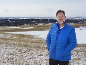 Tom Dechert, who lives in Watermark, stands on the land that has been proposed for a shopping area in Rocky View County, Alta. on Friday, March 26, 2021. Dechert is against the proposal. (Photo by Dre Kwong/Postmedia)