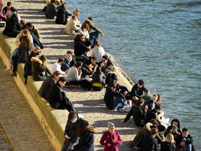 People gather on the banks of the River Seine on a sunny afternoon in Paris, on March 6, 2021, amid the Covid-19 pandemic.