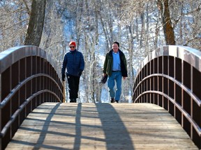 Mike Patterson, left, and Ian Campbell go for a walk in Fish Creek Provincial Park in Calgary on Tuesday, March 2, 2021.