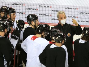 Calgary Flames head coach Darryl Sutter talks with players during practice on Wednesday, March 10, 2021.