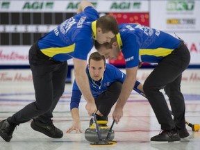 Team Alberta skip Brendan Bottcher delivers his stone as second Brad Thiessen and lead Karrick Martin brush the stone during Draw 4 against Northwest Territories on Saturday night.