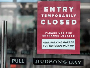 A sign on a Hudson's Bay store in Toronto directs shoppers to curb-side pickup when stores closed in December for COVID lockdown.