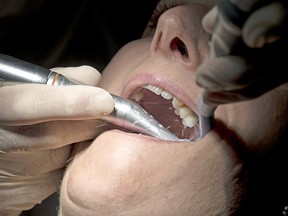 A dentist works on a patient in France. Dentists, teachers and bus drivers in B.C. hope to receive the Oxford-AstraZeneca vaccine.