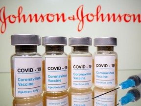 FILE PHOTO: Vials with a sticker reading, "COVID-19 / Coronavirus vaccine / Injection only" and a medical syringe are seen in front of a displayed Johnson & Johnson logo in this illustration taken October 31, 2020. REUTERS/Dado Ruvic/Illustration/File Photo ORG XMIT: FW1