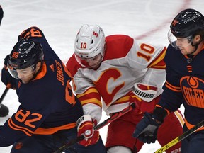 Oilers Caleb Jones and Gaetan Haas put the squeeze on the Calgary Flames' Derek Ryan on Saturday night at Rogers Place in Edmonton.