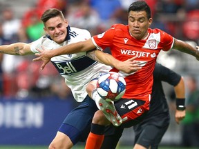 Whitecaps Jake Nerwinski (L) and Cavalry FC Jose Escalante battle for the ball during third round CPL Canadian Championships soccer action between Cavalry FC and Vancouver Whitecaps at BC Place in Vancouver, BC  Wednesday, July 24, 2019. Jim Wells/Postmedia