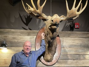 Lance Hurtubise, president of the Vintage Group, and Bruce the Moose in Moose McGuire's new location at 14th Street and Northmount Drive N.W.