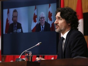 Prime Minister Justin Trudeau speaks as Parliamentary Secretary to the Minister of Public Safety and Emergency Preparedness Joel Lightbound, left, and Minister of Public Safety and Emergency Preparedness Bill Blair listen at a press conference in Ottawa on Tuesday, Feb. 16, 2021.