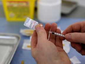 A health-care worker prepares a syringe with a dose of the Moderna COVID-19 vaccine in Calais, France, on March 4, 2021.