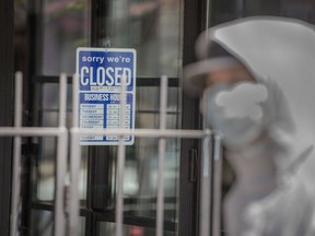 A pedestrian passes a closed store in Toronto.