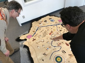 Artist Adrian Stimson, right, and University of Calgary history professor George Colpitts look at Stimson's map of the Calgary Stampede through the eyes of First Nations. Courtesy, Sean Lindsay.