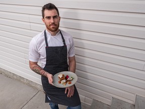 Alex Edmonson poses for a photo with a braised pork belly and vegetables dish outside his house in Calgary on Thursday, April 8, 2021.