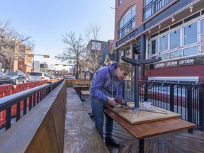 Cam Dobranski, owner of Container Bar and Eatcrow snack bar in Kensington, sets up a patio outside his restaurant on Thursday, April 15, 2021. The current COVID-19 restrictions in Alberta bans indoor dining while patios can stay operational.