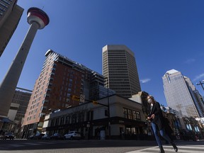 A masked pedestrian crosses the Centre Street in downtown Calgary on Friday, April 16, 2021.