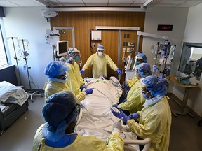 Health-care staff get ready to prone a 47-year-old woman who has COVID-19 and is intubated on a ventilator in the intensive care unit at the Humber River Hospital during the COVID-19 pandemic in Toronto on Tuesday, April 13, 2021.