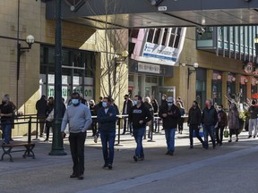 Albertans born in 1981 and earlier stand in line for the drop-in appointments to receive their AstraZeneca vaccines at the immunization clinic at Telus Convention Centre on Tuesday, April 20, 2021.