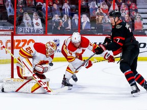 Ottawa Senators winger Brady Tkachuk tracks the puck against Calgary Flames defenceman Juuso Valimaki as goaltender Jacob Markstrom makes a save at the Canadian Tire Centre in Ottawa on March 24, 2021.