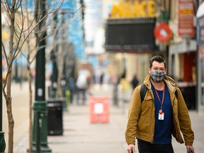A masked man walks down Stephen Ave. in Calgary on Thursday, April 8, 2021.