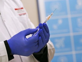 Walden Shoppers Drug Mart pharmacist Brian Jones prepares to immunize a customer with the Pfizer-BioNTech COVID-19 vaccine in Calgary on Monday, April 5, 2021.