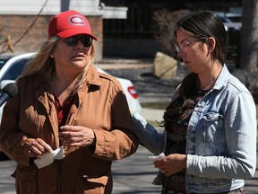Dawn Swimmer, left, is comforted by her daughter on Wednesday April 20, 2021 while visiting a memorial at the site where her partner Chris Muise was hit and killed by a pick-up truck while walking home on Edmonton Trail on Tuesday.