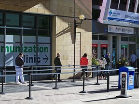 Calgarians wait to enter the COVID-19 vaccination clinic in downtown Calgary on Wednesday, April 21, 2021.