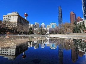 The downtown Calgary skyline is reflected in a pool of water at Olympic Plaza on Monday, April 26, 2021. Calgary city council is considering a 10-year plan to revitalize the downtown core.