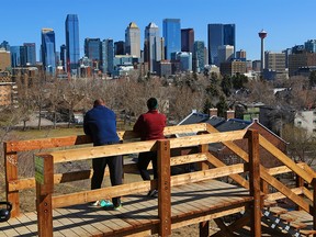Rob Lippa and Crystal Kemick look towards the downtown Calgary skyline from Mount Royal on April 26, 2021.