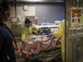 Health care staff tend to a COVID-19 patient in an ICU unit at Peter Lougheed in this file photo on Nov. 14, 2020.