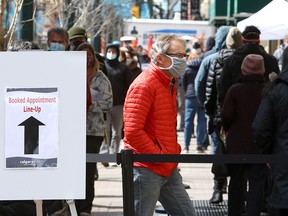 People line up for COVID-19 vaccinations at the Telus Convention Centre on Stephen Avenue Thursday, April 22, 2021.