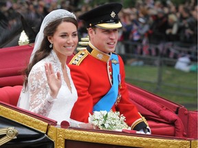 In this file photo taken on April 29, 2011, Britain's Prince William and wife Kate, Duchess of Cambridge. wave as they travel in the 1902 State Landau carriage along the Processional Route to Buckingham Palace, in London on their wedding day.  A million people lined London's streets and two billion television viewers worldwide watched the event.