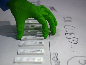A health worker handles rapid antigen test devices for the COVID-19 coronavirus during a screening of 5,000 people who later on March 27, 2021, will attend a rock music concert in Barcelona during which attendees will wear face masks but the social distancing rule will not be complied as part of a study on virus propagation.